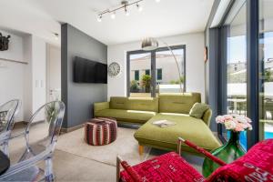 a living room with a green couch and a tv at Casa Seal by Briskva in Funtana