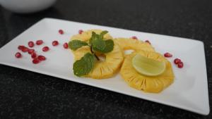 a white plate with fruit and a lime on it at The King's Hotel in Tuticorin