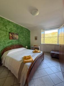 a bedroom with a bed with a green wall at Agriturismo Gli Ulivi in Garlenda +48 photos