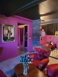 a room with pink walls and a table and chairs at Elämysmajoitus Olipa Kerran in Turku