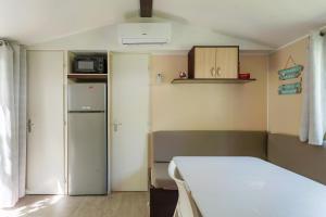 a small room with a bed and a refrigerator at Mobil-home - Le 147 aux Iscles in La Roque-dʼAnthéron