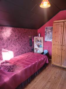 a bedroom with pink walls and a large bed at Elämysmajoitus Olipa Kerran in Turku