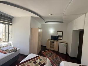 ein Zimmer mit zwei Betten und einem Schreibtisch mit Fernseher in der Unterkunft City Hotel in Ayii Trimithias