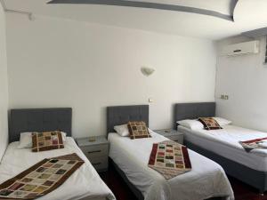 zwei Betten in einem Zimmer mit weißen Wänden in der Unterkunft City Hotel in Ayii Trimithias
