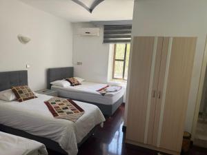 ein Zimmer mit zwei Betten und einem Fenster in der Unterkunft City Hotel in Ayii Trimithias