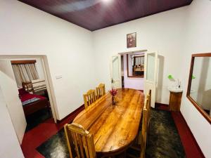 a dining room with a wooden table and chairs at Lodgepole Pine Resorts in Welimada