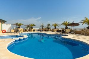 a large blue swimming pool with tables and umbrellas at Hotel Costa Blanca Rojales in Rojales