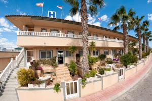 a building with palm trees in front of it at Hotel Costa Blanca Rojales in Rojales