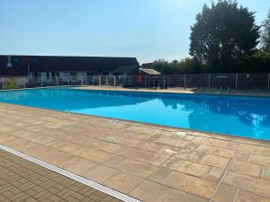 a large swimming pool with blue water at Sea & Stay Bredene Zeewind 2 in Bredene