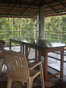 a wooden table with two chairs and a glass top at Sapthagiri Streamways in Madikeri
