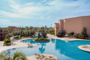 a pool at a resort with chairs and buildings at Grand Mogador Aqua Resort in Marrakesh