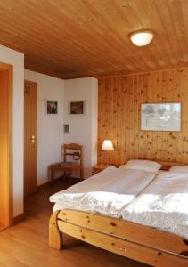 a bedroom with a large bed with a wooden ceiling at Chalet Bühlweidli by Ferienlenk in Lenk