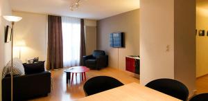 a living room with a couch and a table and a chair at Les Negociants in Vevey