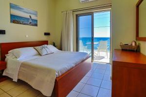 a bedroom with a bed and a view of the ocean at Skinos Apartments in Plakias