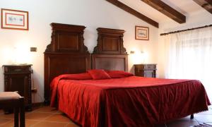 a bedroom with a red bed with a red blanket at Agriturismo Kogoj in Medea