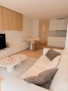 a living room with a white couch and a table at Studio Nacre Knokke in Knokke-Heist