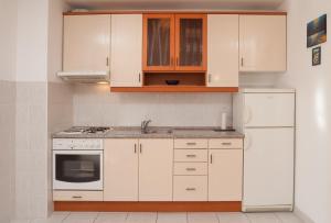 a kitchen with white cabinets and a white refrigerator at City Apartment Mima in Makarska
