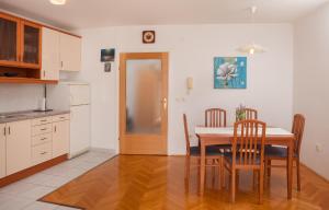 een keuken met een tafel en stoelen en een deur bij City Apartment Mima in Makarska