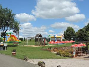 a park with a playground with a slide and slides at Camping 3 étoiles - Piscine - ccbgaci in Illiers