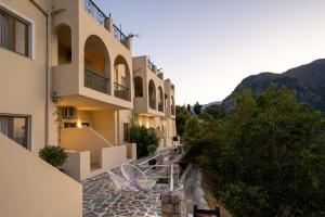 a view of a building with chairs on a walkway at Thomas Nice View Retreat in Argyroupolis