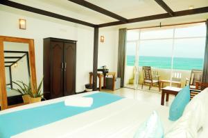 a bedroom with a bed and a view of the ocean at Cozy Cocos Midigama in Ahangama