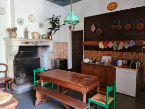 a kitchen with a wooden table and a fireplace at Chateau de Barral - Piscine privée in Hauterives