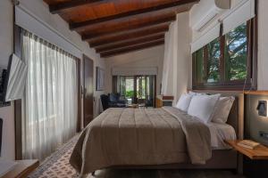 a bedroom with a large bed and windows and a desk at Valeni Boutique Hotel & Spa in Portaria +47 photos