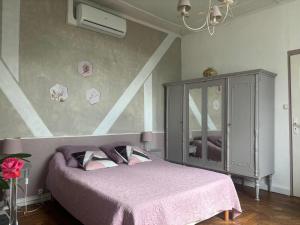 a bedroom with a bed with a pink blanket at Le Chalet des Vignes in Saint-Laurent-des-Vignes