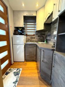 a kitchen with a white refrigerator and a white dishwasher at Paradiso Apartmanház in Gyula