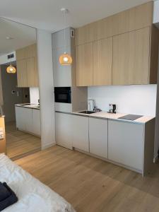 a kitchen with white cabinets and wooden floors at Baltic Infinity Beach Spa in Międzyzdroje