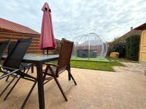 a table with two chairs and an umbrella on a patio at Paradiso Apartmanház in Gyula
