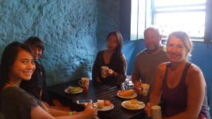 a group of people sitting around a table eating food at Hostel Galeria 13 in Salvador