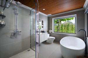 a bathroom with a shower and a toilet and a window at Hoa Lư - An Resort in Ninh Binh
