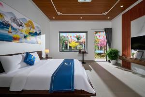 a bedroom with a large white bed and a tv at Hoa Lư - An Resort in Ninh Binh