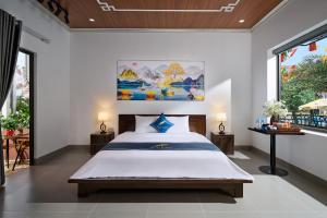 a bedroom with a bed and a painting on the wall at Hoa Lư - An Resort in Ninh Binh