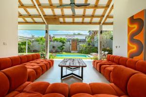 a room with orange leather chairs and a table at Bingin Villas Luxury, Concierge and Security in Uluwatu