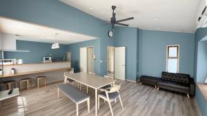 a living room with blue walls and a table and chairs at Villa Miura Beach -ヴィラ三浦海岸- in Miura