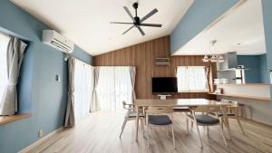 a dining room with blue walls and a table and chairs at Villa Miura Beach -ヴィラ三浦海岸- in Miura