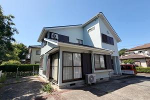 a white house with a lot of windows at Villa Miura Beach -ヴィラ三浦海岸- in Miura