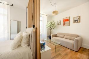 a bedroom with a bed and a couch and a glass table at Downtown by Max, Refuge in city center in Mulhouse