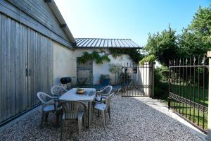 a patio with a table and chairs and a fence at Gîte Lilas de mer in Ponthoile