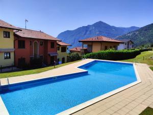 a swimming pool in front of a house with mountains at IseoLakeRental - Casa Amici in Riva di Solto