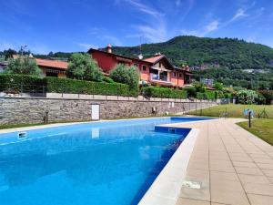 a large blue swimming pool next to a stone wall at IseoLakeRental - Casa Amici in Riva di Solto