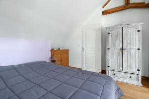 a bedroom with a blue bed and a wooden cabinet at Gîte Lilas de mer in Ponthoile