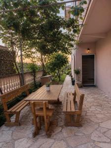 a wooden picnic table and benches on a patio at Apartman VUKAN in Budva