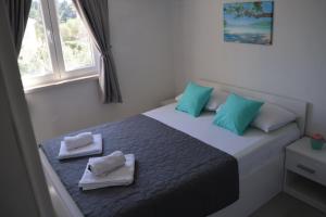 a bedroom with a bed with blue and green pillows at Seba Apartments in Korčula