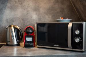 a microwave sitting on a counter next to a toaster at Downtown by Max, Refuge in city center in Mulhouse