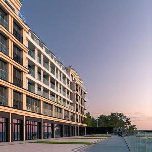 a large office building with a lake in front of it at Baltic Infinity Beach Spa in Międzyzdroje