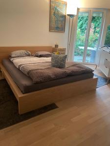 a bed with a wooden frame in a bedroom at Your exclusive 2 room & 2 bathroom natural holiday home in Winterthur