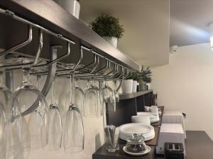 a kitchen with glasses and utensils hanging on a wall at HOF Apartments in Kaunas +27 photos